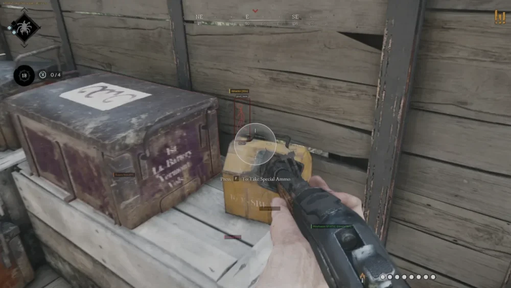 First-person perspective of a video game player aiming a gun at a yellow ammo box on wooden crates, set in a rustic environment. Text overlays show game instructions.
