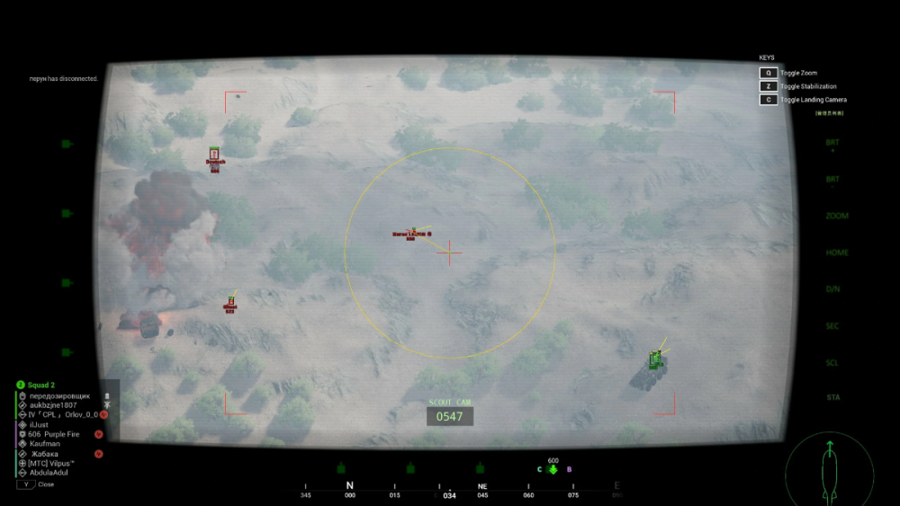 Aerial view from a drone camera displaying a desert landscape with scattered greenery. Smoke rises from a target, marked by indicators on the screen, suggesting a military operation. The interface shows coordinates and status details in a tactical environment.