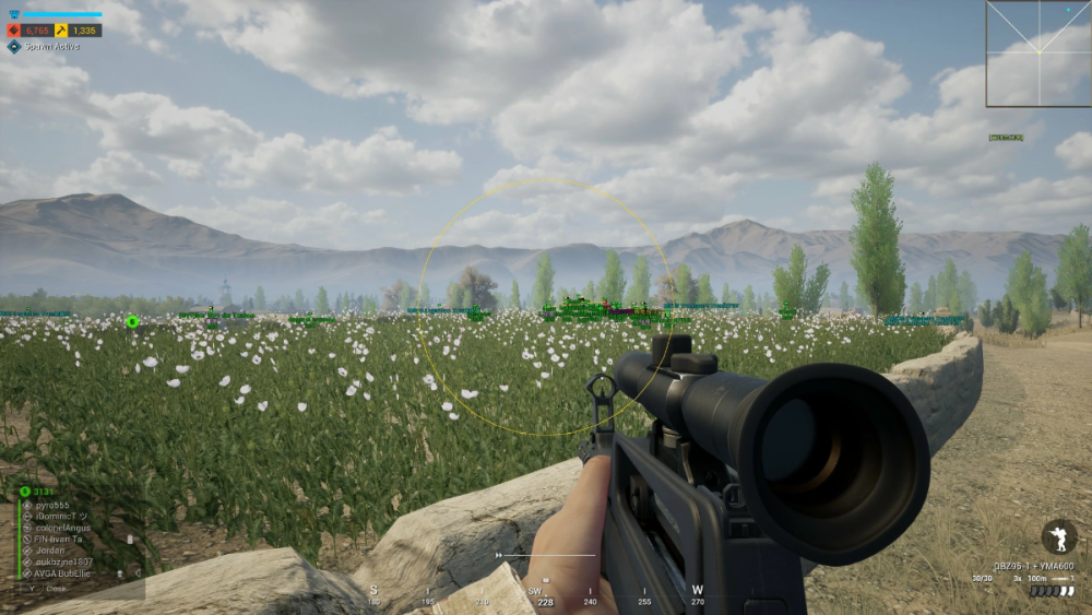 First-person view in a video game, holding a scoped rifle. The setting is a vast field with white flowers, surrounded by mountains, and a partly cloudy sky. The tone is tense and focused.