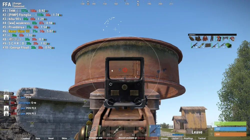 First-person shooter game screen shows a player aiming at a rusty water tower through a gunsight. Scoreboard and player stats are visible. Sky is clear.